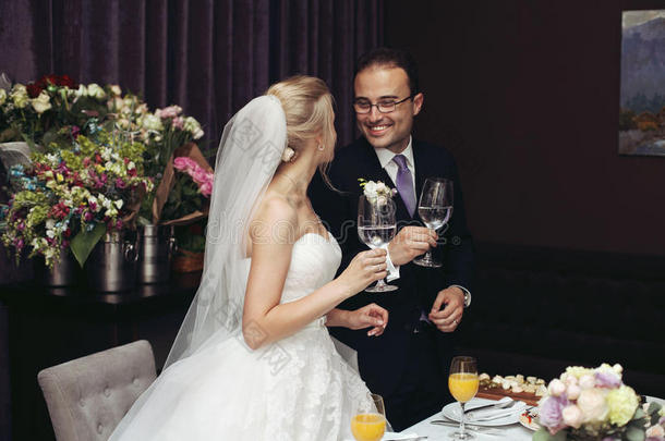 <strong>喜气</strong>洋洋的新婚夫妇在婚宴上喝香槟和祝酒