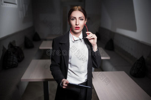 商务女士穿着西装，红唇和平板电脑；
