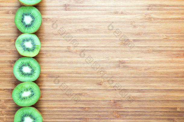 <strong>新鲜</strong>成熟的绿色猕猴桃<strong>切</strong>成两<strong>半</strong>，放在木板上。 自然<strong>水果</strong>的概念。 健康饮食主题的背景。
