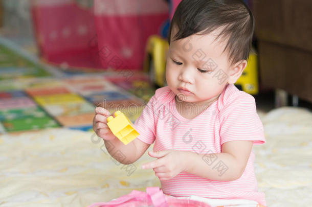 亚洲蹒跚学步的孩子<strong>独自在家</strong>里玩拼图玩具。