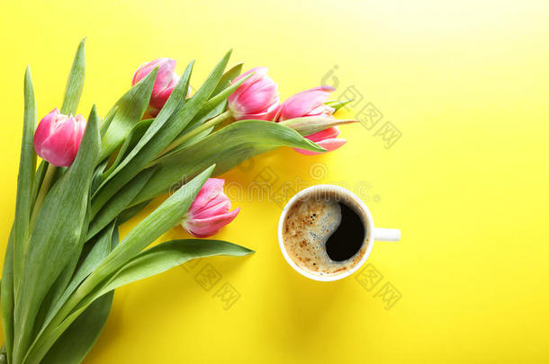 一杯咖啡和粉<strong>红</strong>色郁金香在<strong>黄色背景</strong>，顶部视图
