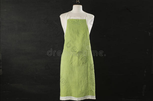 黑色背景的人体模型上的绿色厨房围裙