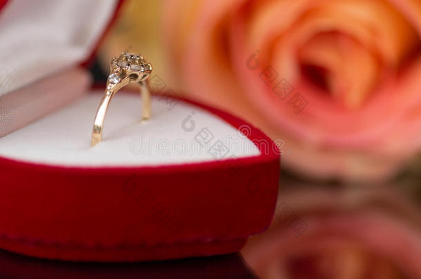 盒子里的黄金订婚戒指和茶玫瑰。