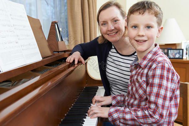 和音乐老师一起上钢琴课的男孩