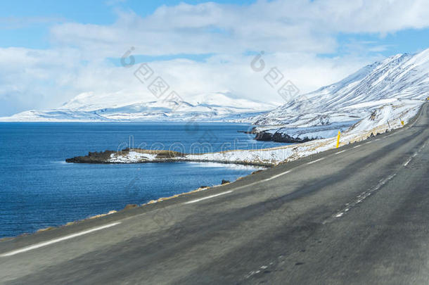 空的路通向雪山，一边有一个湖