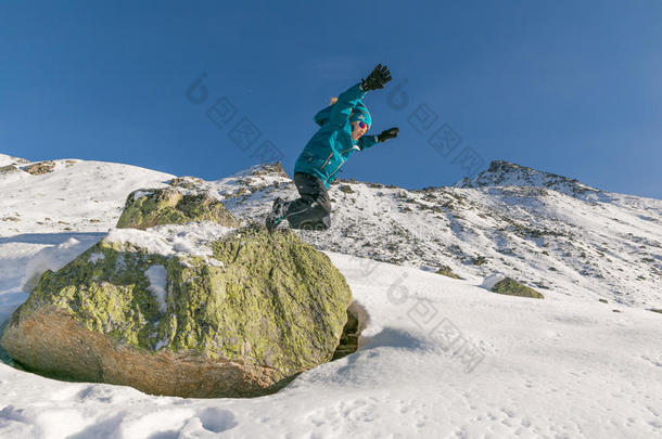 男孩从岩石<strong>跳入</strong>雪中