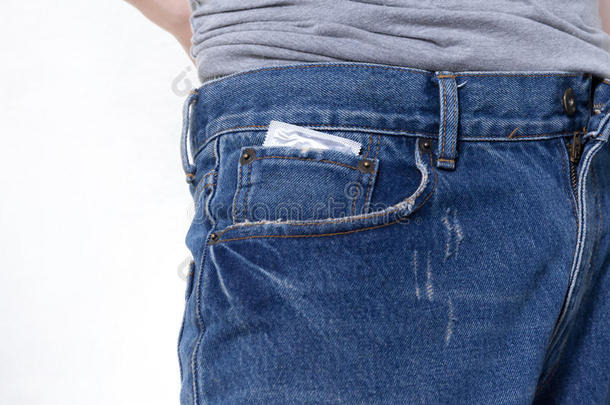 蓝色牛仔裤口袋里的避孕套在孤立的白色背景上