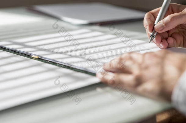 男子签署合同或文件的特写低角度视图