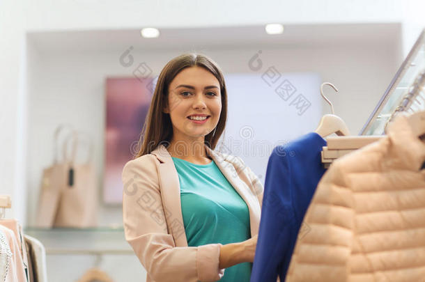 在商场挑选衣服的快乐年轻女人