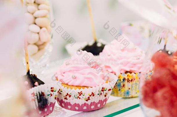甜点甜美味的纸杯蛋糕在糖果棒在桌子上。 美味的汗水