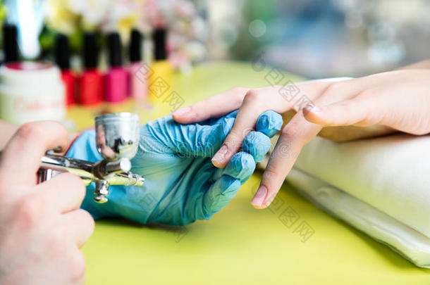 一位在美甲沙龙接受指甲锉美容师修剪指甲的妇女的特写镜头。 去修指甲的女人