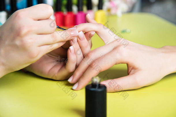 一位在<strong>美甲沙龙</strong>接受指甲锉美容师修剪指甲的妇女的特写镜头。 去修指甲的女人