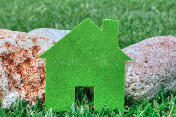 生态房子的概念在绿色的草和石头，绿色生态房子的图标在自然