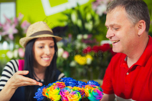 花店招待男顾客在商店买花。