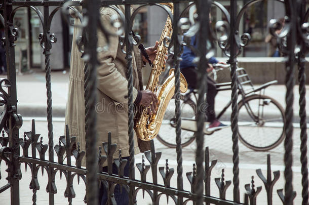 非洲街头音乐家演奏爵士乐在萨克斯管投掷格子与自行车剪影，城市生活在阿姆斯特丹