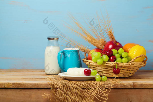 木制桌子上的水果篮和乳制品。 犹太节日的背景