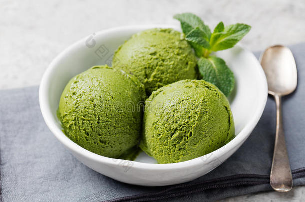 绿茶<strong>抹茶冰淇淋</strong>勺在白色碗在灰色的石头背景