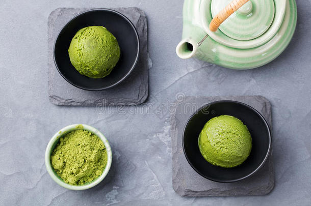 绿茶抹茶冰淇淋勺在碗中的灰色石头背景顶部的视图