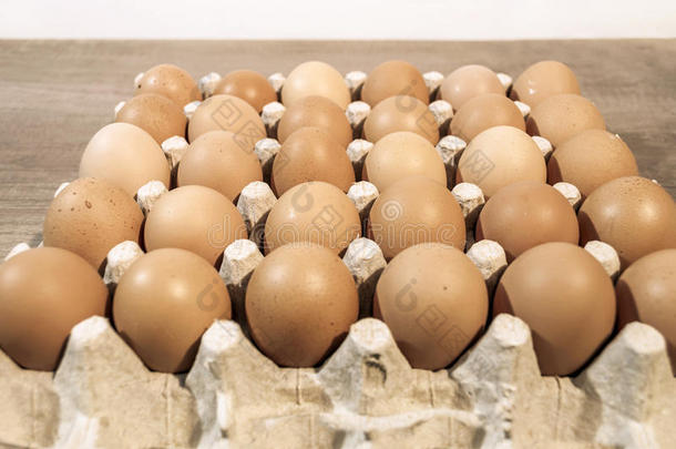 许多鸡蛋在纸箱包装上的木制桌子上准备烘焙