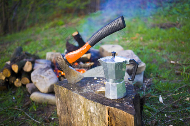 火旁的咖啡机和斧头。