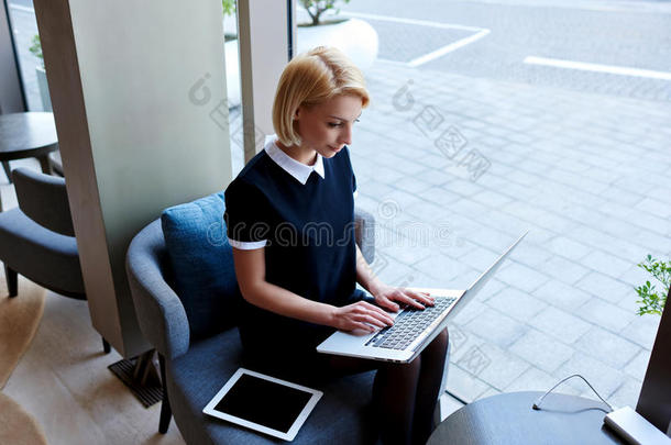 女商人在咖啡馆的咖啡休息期间，通过便携式上网本在互联网上查看电子邮件