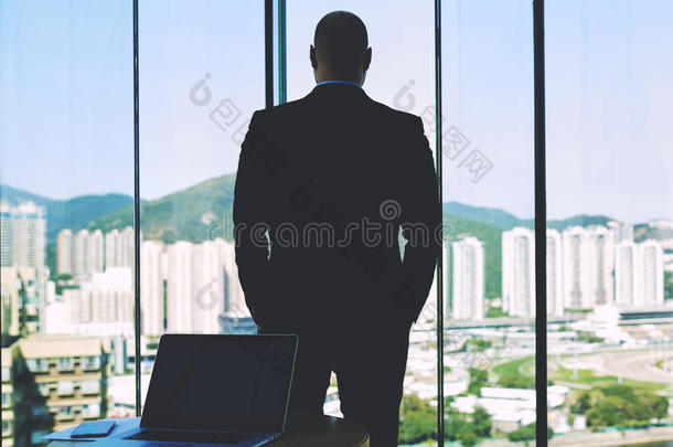 一个自信的企业家正在寻找大办公室的窗口