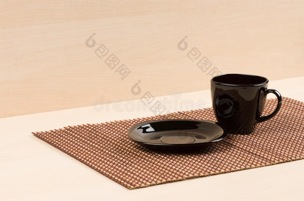 黑色盘子站在桌子上的红茶杯附近。