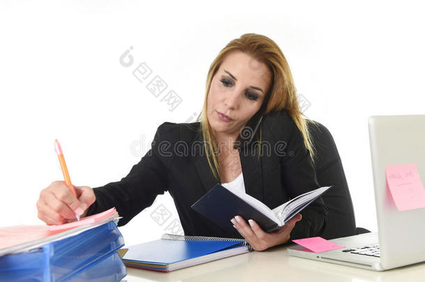 忙碌的女商人在压力下工作，用笔记本电脑在手机上多任务交谈