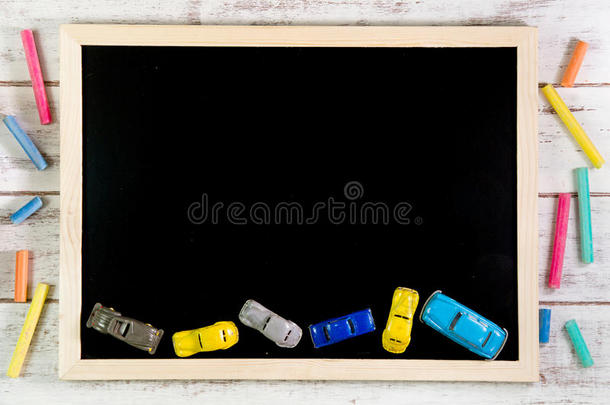 木制桌子上的空白黑板和汽车玩具。模板模拟f