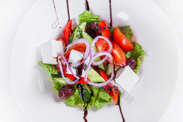 希腊沙拉配新鲜蔬菜。 白色的盘子