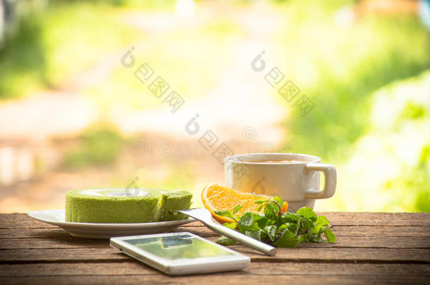 背景水果和绿茶蛋糕和薄荷智能手机.on带rela的木质背景户外景观和假日