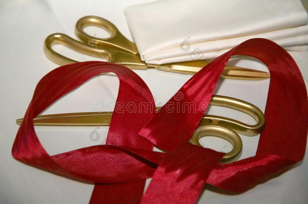 剪下红色的丝带。 金色剪刀和红色丝带的盛大开幕，展示。 胶带和剪刀。