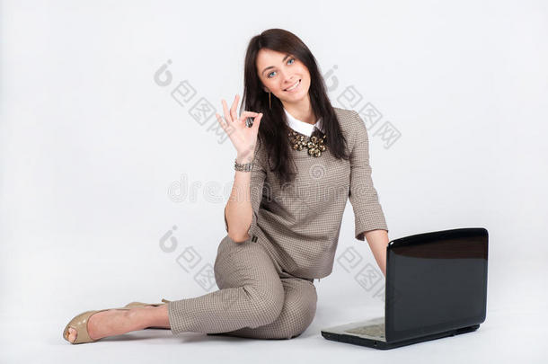 商务女士，漂亮的黑发女人，穿着灰色西装，用笔记本电脑工作