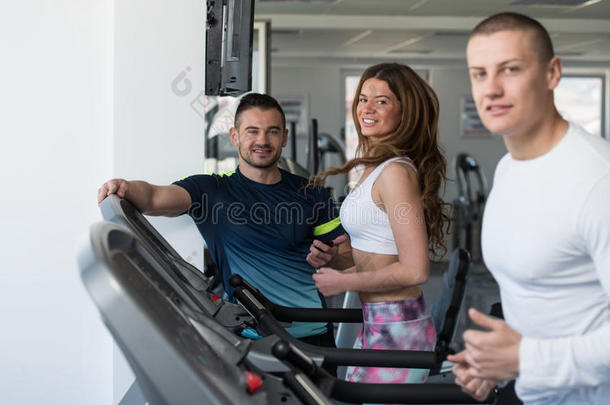 一群人在健身房的跑步机上跑步