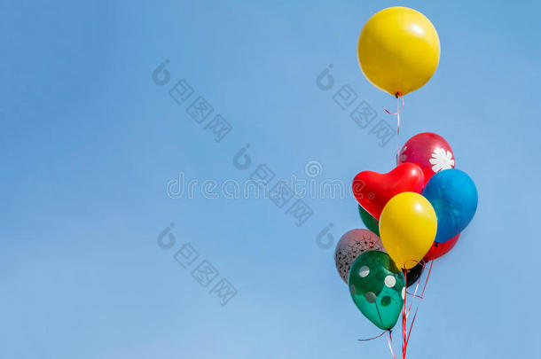 五颜六色的气球漂浮在漂浮在明亮的蓝天上。