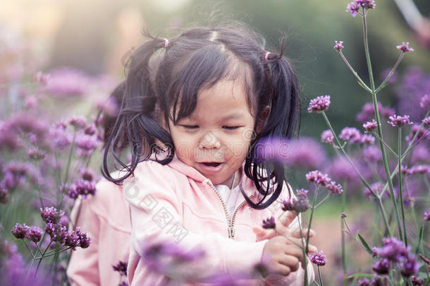 快乐的小女孩在花圃里奔跑嬉戏