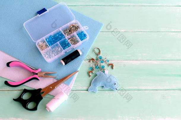 可爱的感觉海豚钥匙扣与珠子。 蓝色毡海动物钥匙链。 用于创建工艺品的材料和工具