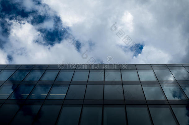 商业现代玻璃办公楼与多云的天空在透视