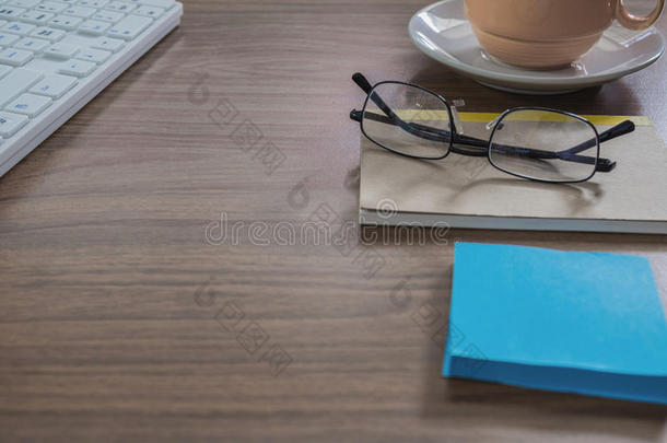 木制办公室桌子上的眼镜和记事本