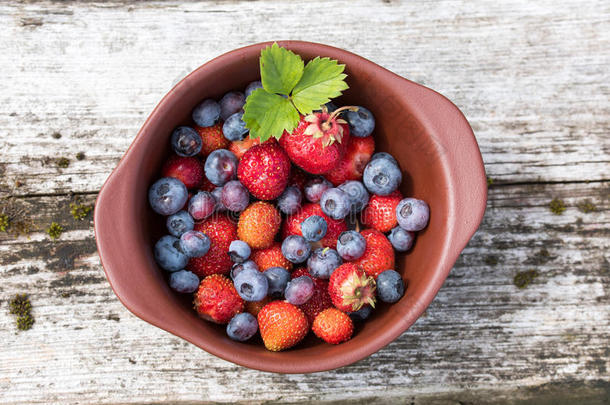 新鲜<strong>采摘</strong>的蓝莓和<strong>草莓</strong>在乡村餐桌上。