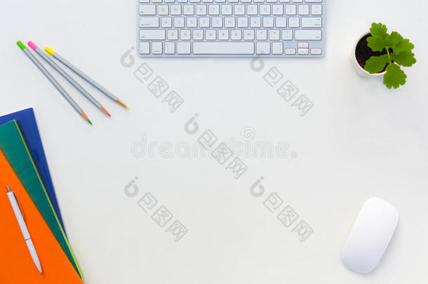 创意办公室明亮的桌子，彩色杂志，铅笔，电脑和花