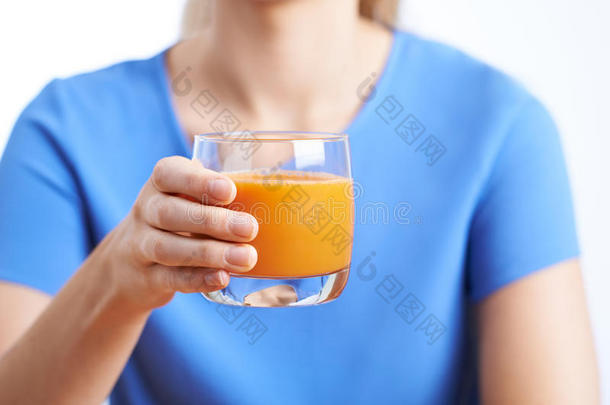 靠近女人喝一杯健康的胡萝卜汁