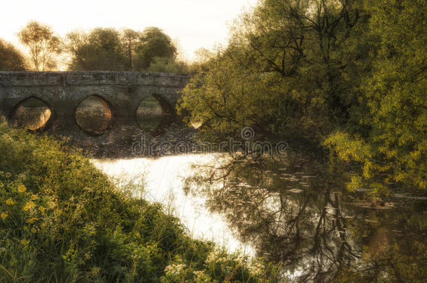 美丽的日出景观的图像流动在英国中世纪的桥梁与发光的阳光在背景
