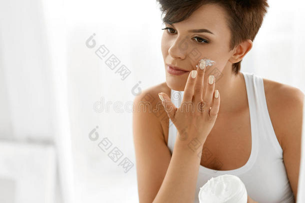 美容护肤。 美丽的女人涂化妆品面霜