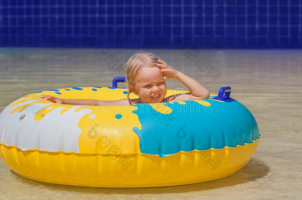孩子日光浴，在游泳池里用充气玩具游泳