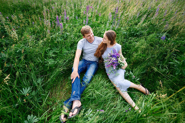一对相爱的夫妇躺在夏日草地上的草地上