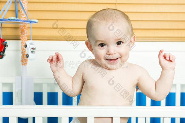 婴儿在白色婴儿床托儿所内部和床上用品的孩子