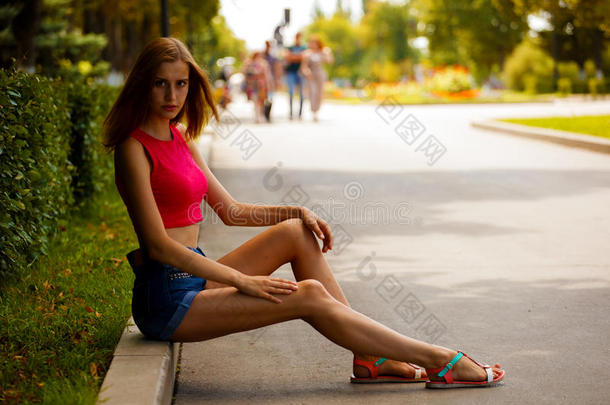 女孩坐在公园里，路边的边缘在路边