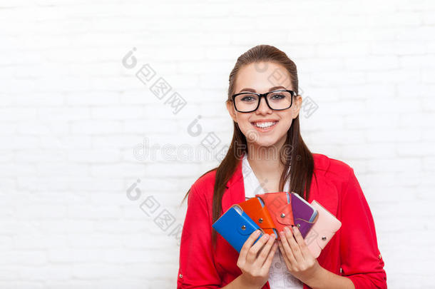 女商人拿着名片，钱包，快乐的微笑，穿红色夹克