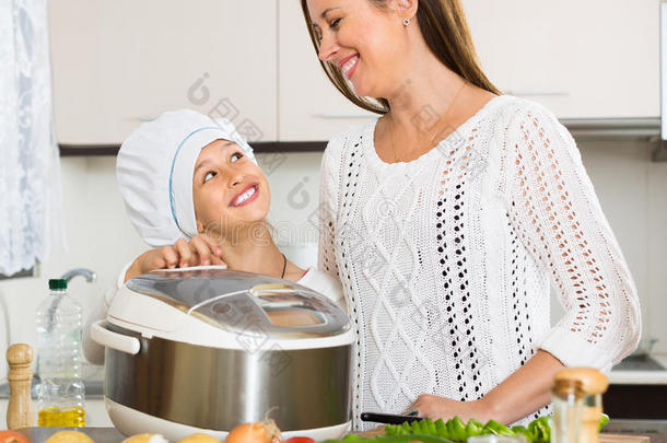 女孩和她妈妈拿着电饭锅